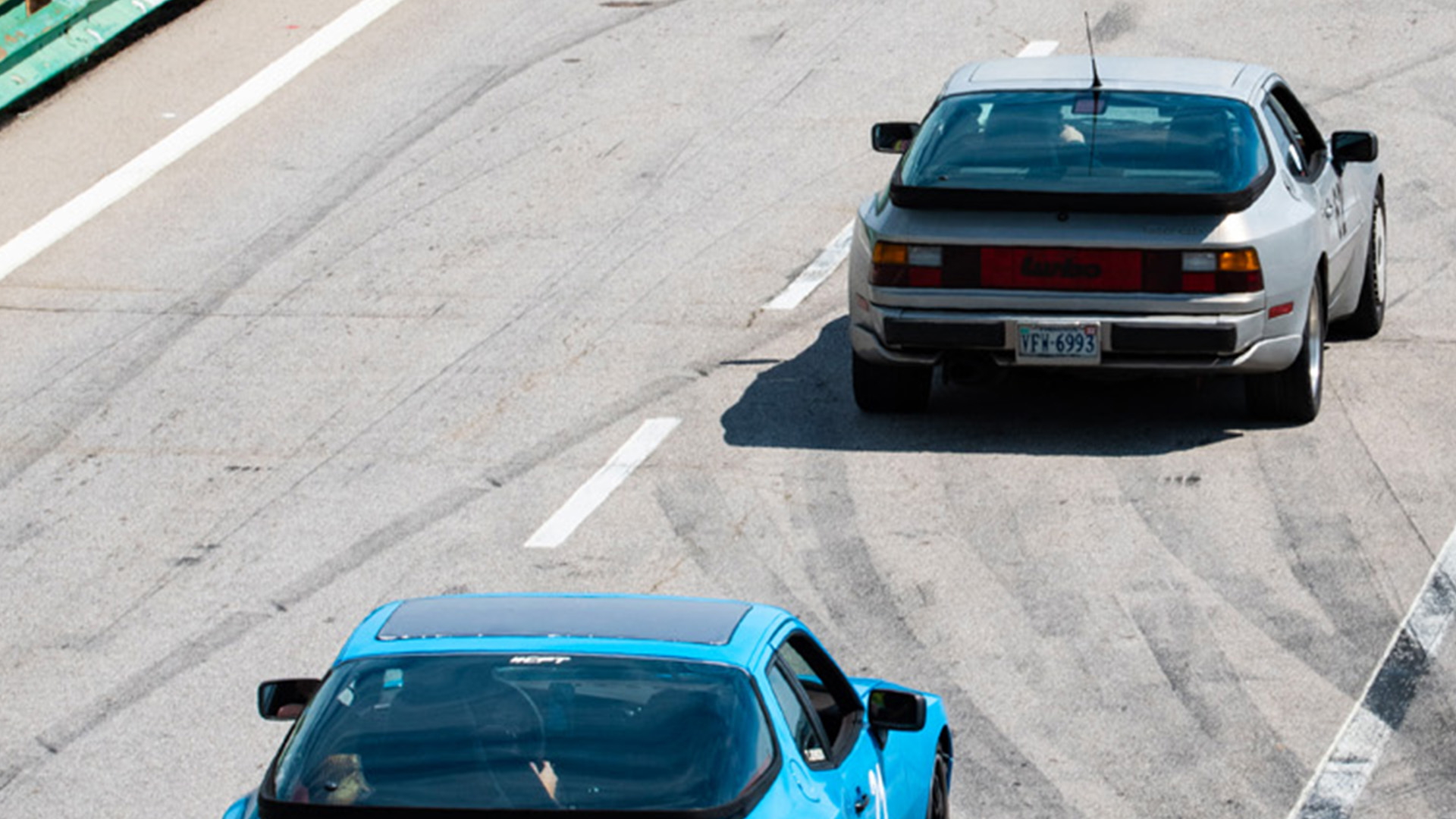 Blue and silver Porsches on track