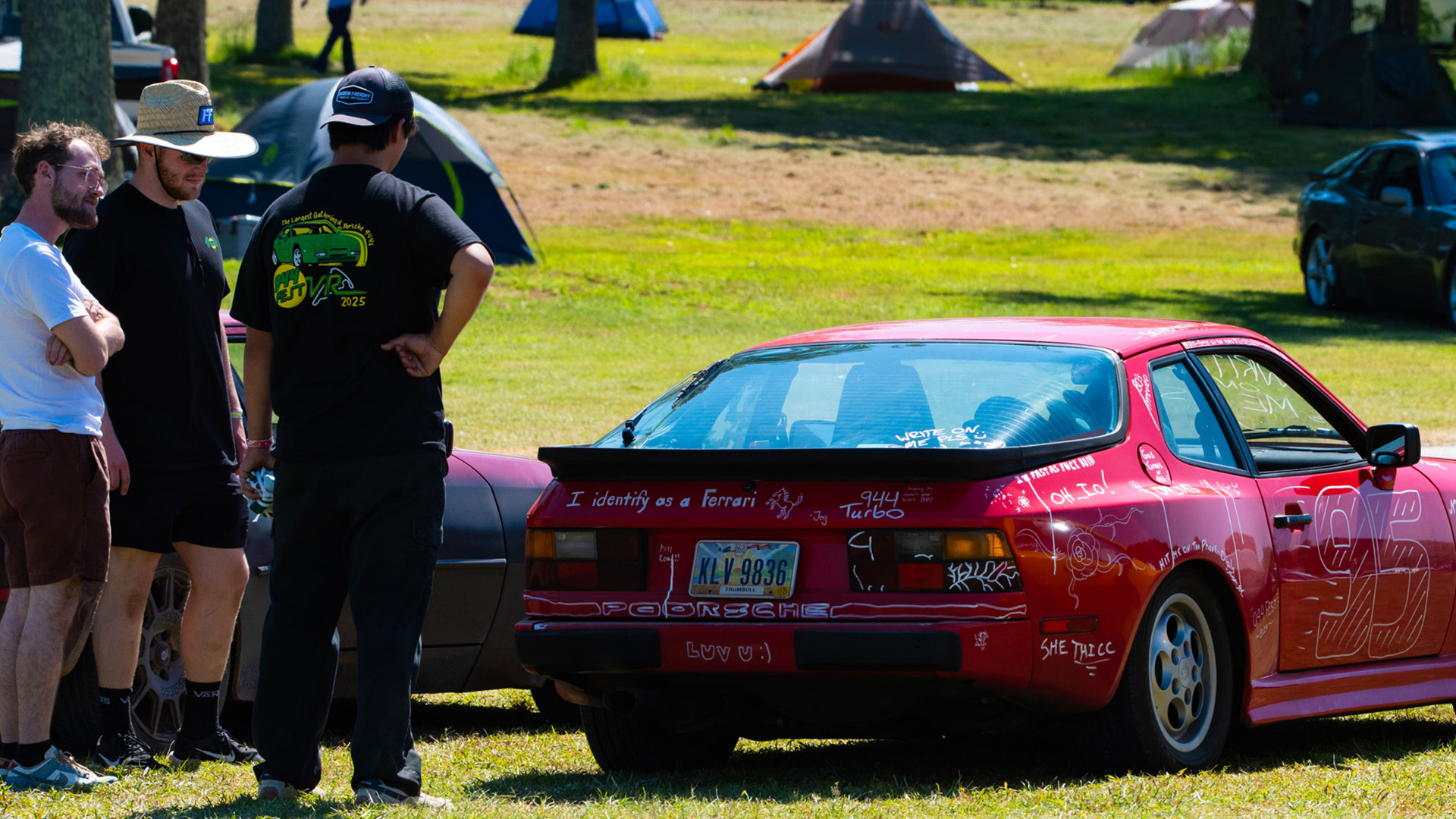 Enthusiasts around chalk-covered car